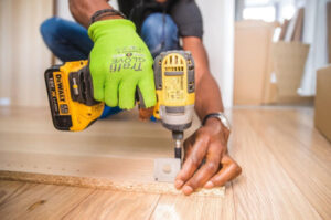  A general contractor drilling holes into a wood plank